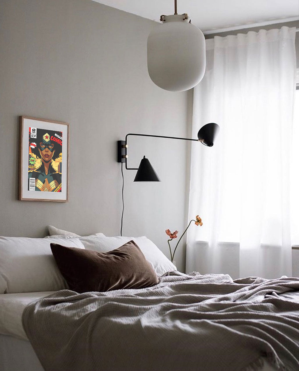 Modern bedroom with a bed, wall lamp, and framed artwork.